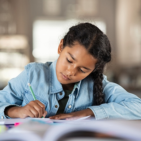 Fotografía de una niña escribiendo en un cuaderno.